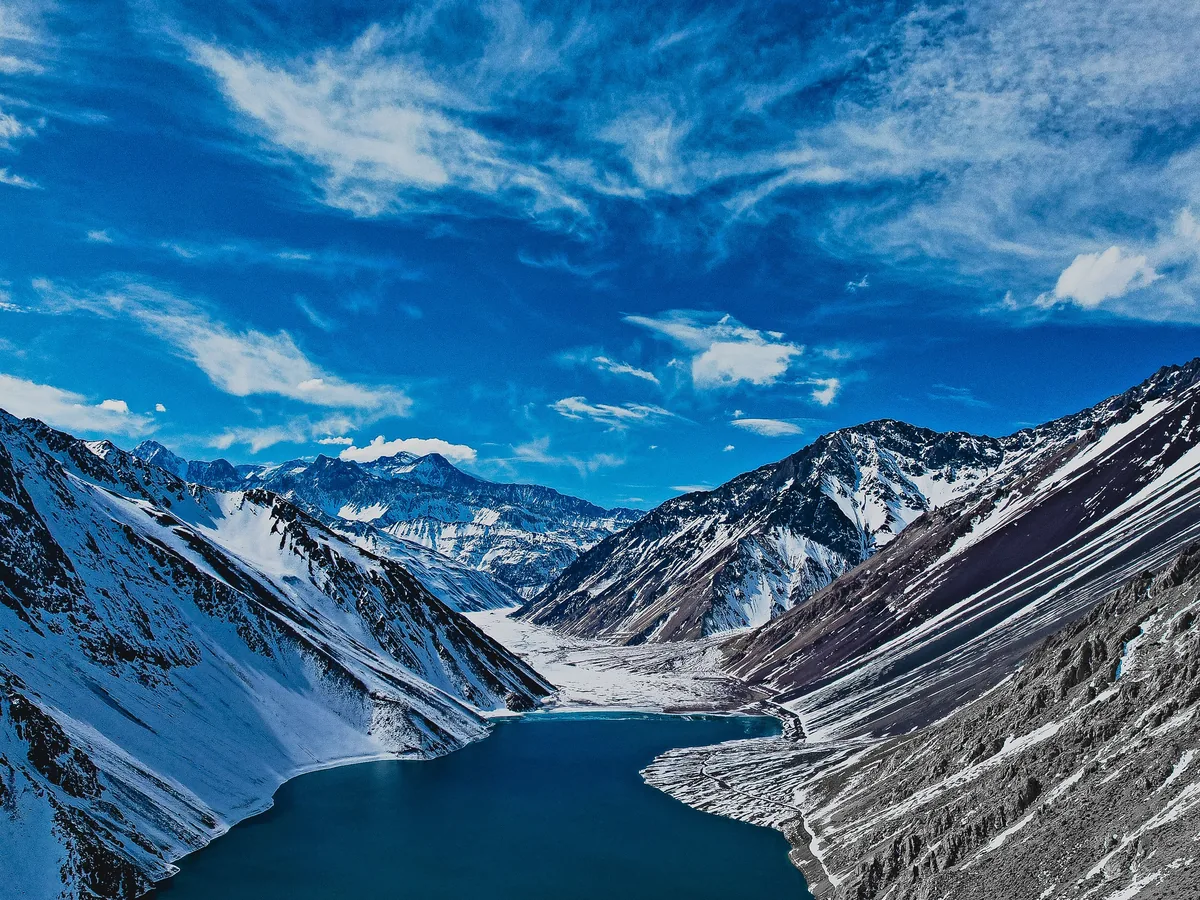 Aerial view of the Embalse El Yeso reservoir under snow, flanked by the Andes above Santiago